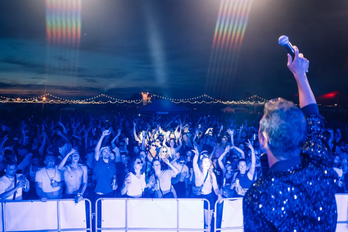 Deejay Plus bei einem Musikfestival mit Publikum, Beleuchtung und DJs.
